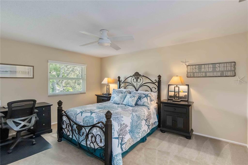 2240 Stickney Point Road, Unit 238 Sarasota, FL 34231 - Photo 9 of 17 a bedroom with a bed and a chandelier