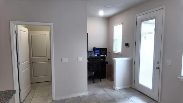 a view of a kitchen with refrigerator and an empty room
