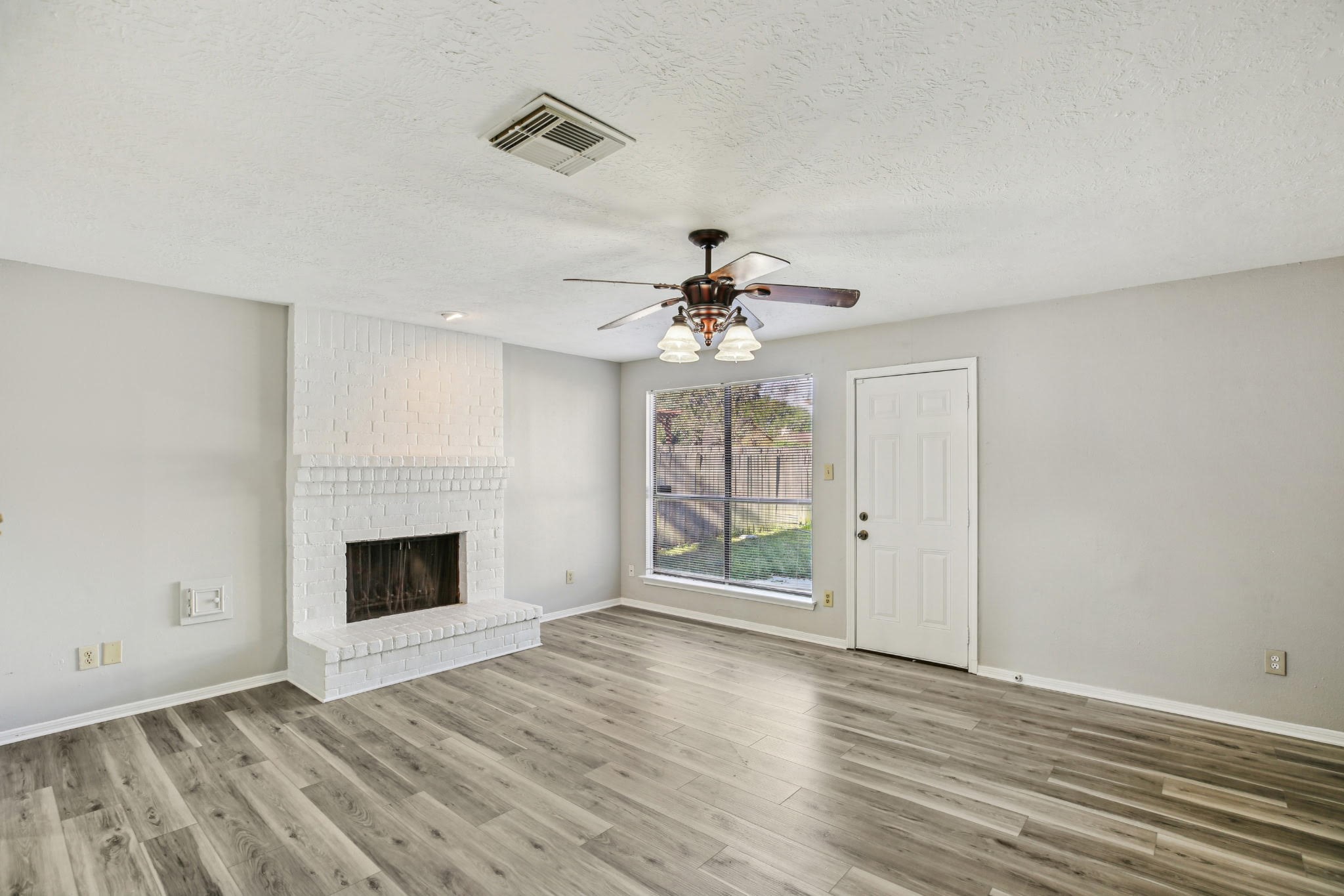 3715 Wells Mark Drive Humble, TX 77396 - Photo 11 of 16 a view of an empty room with wooden floor fireplace and a window
