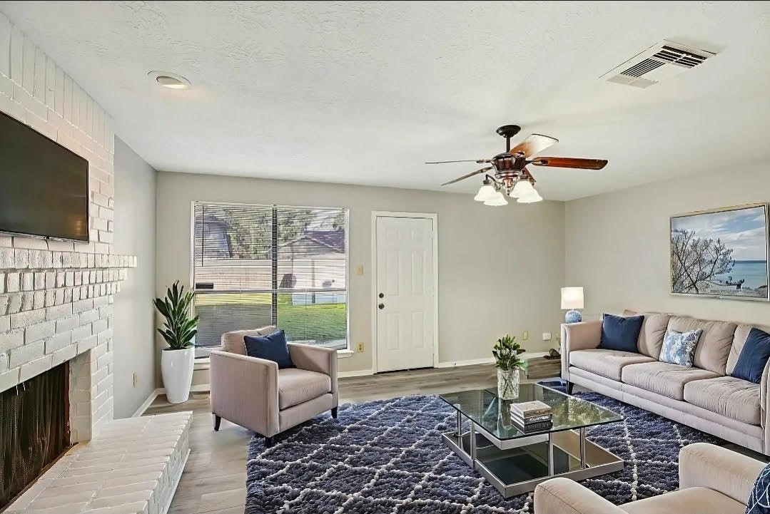 3715 Wells Mark Drive Humble, TX 77396 - Photo 14 of 16 a living room with furniture a fireplace and a flat screen tv