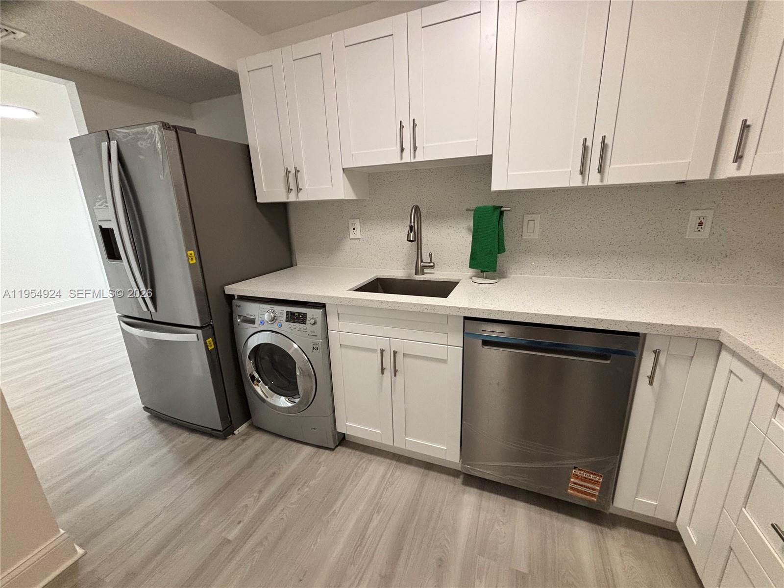 9301 Southwest 92nd Avenue, Unit A320 Miami, FL 33176 - Photo 11 of 20 a kitchen with a refrigerator sink and cabinets
