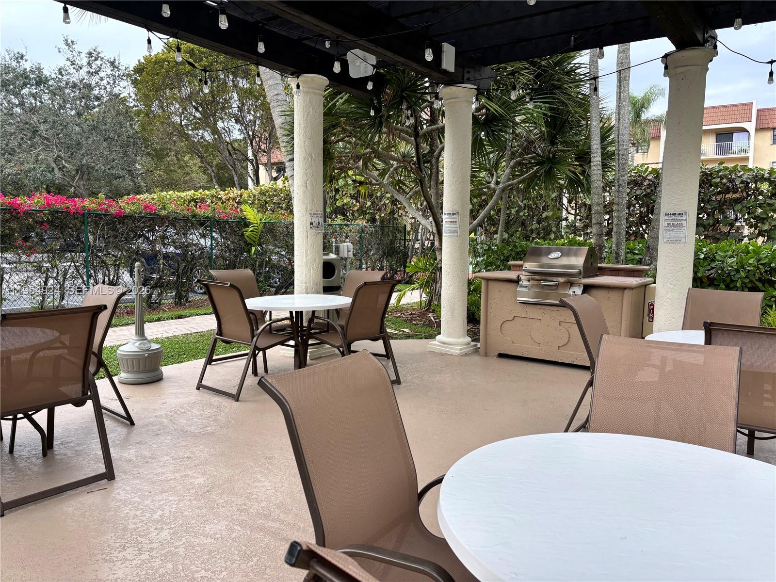 9301 Southwest 92nd Avenue, Unit A320 Miami, FL 33176 - Photo 14 of 20 a view of a patio with a table chairs and a potted plant