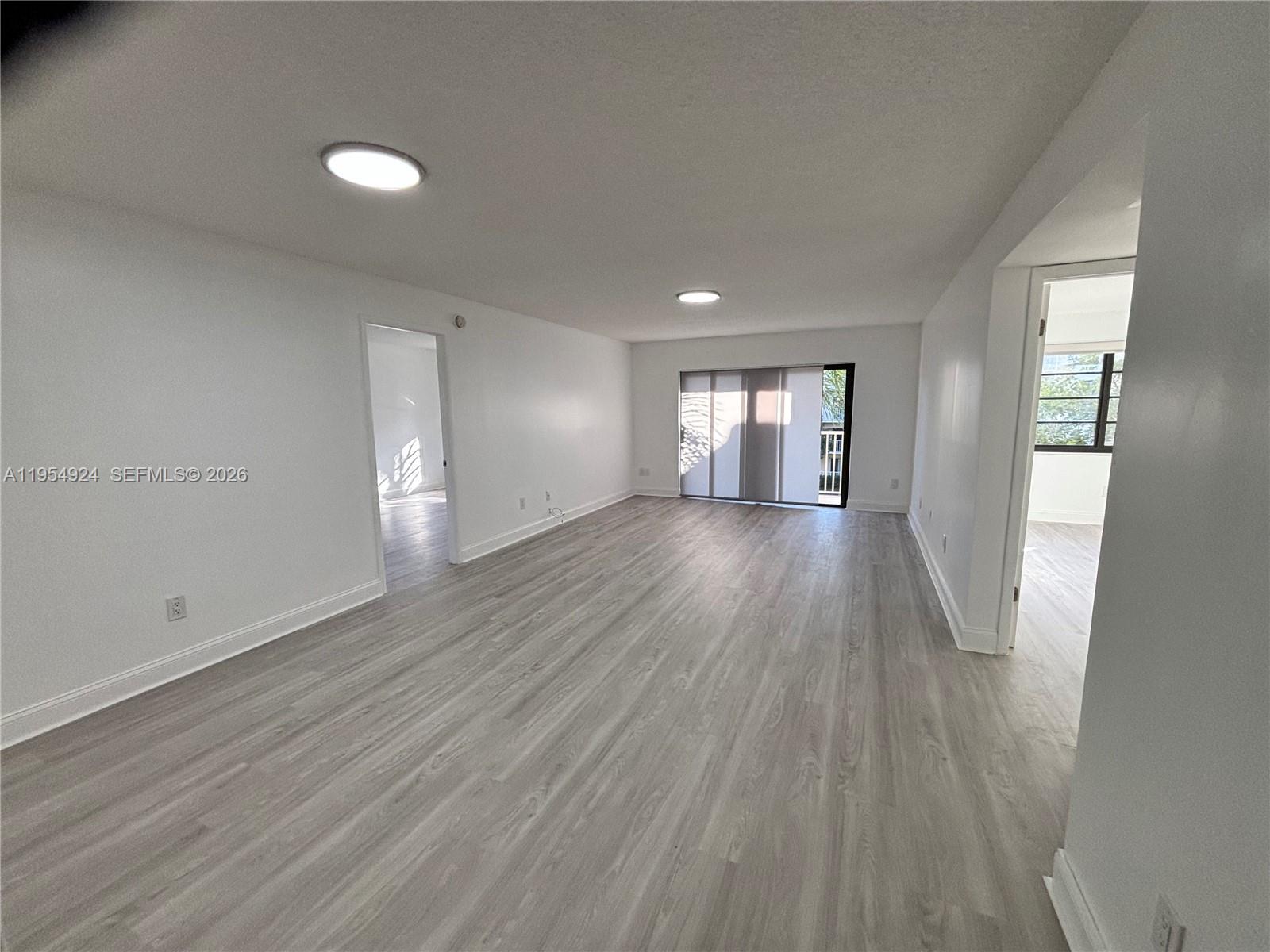 9301 Southwest 92nd Avenue, Unit A320 Miami, FL 33176 - Photo 2 of 20 an empty room with wooden floor and windows