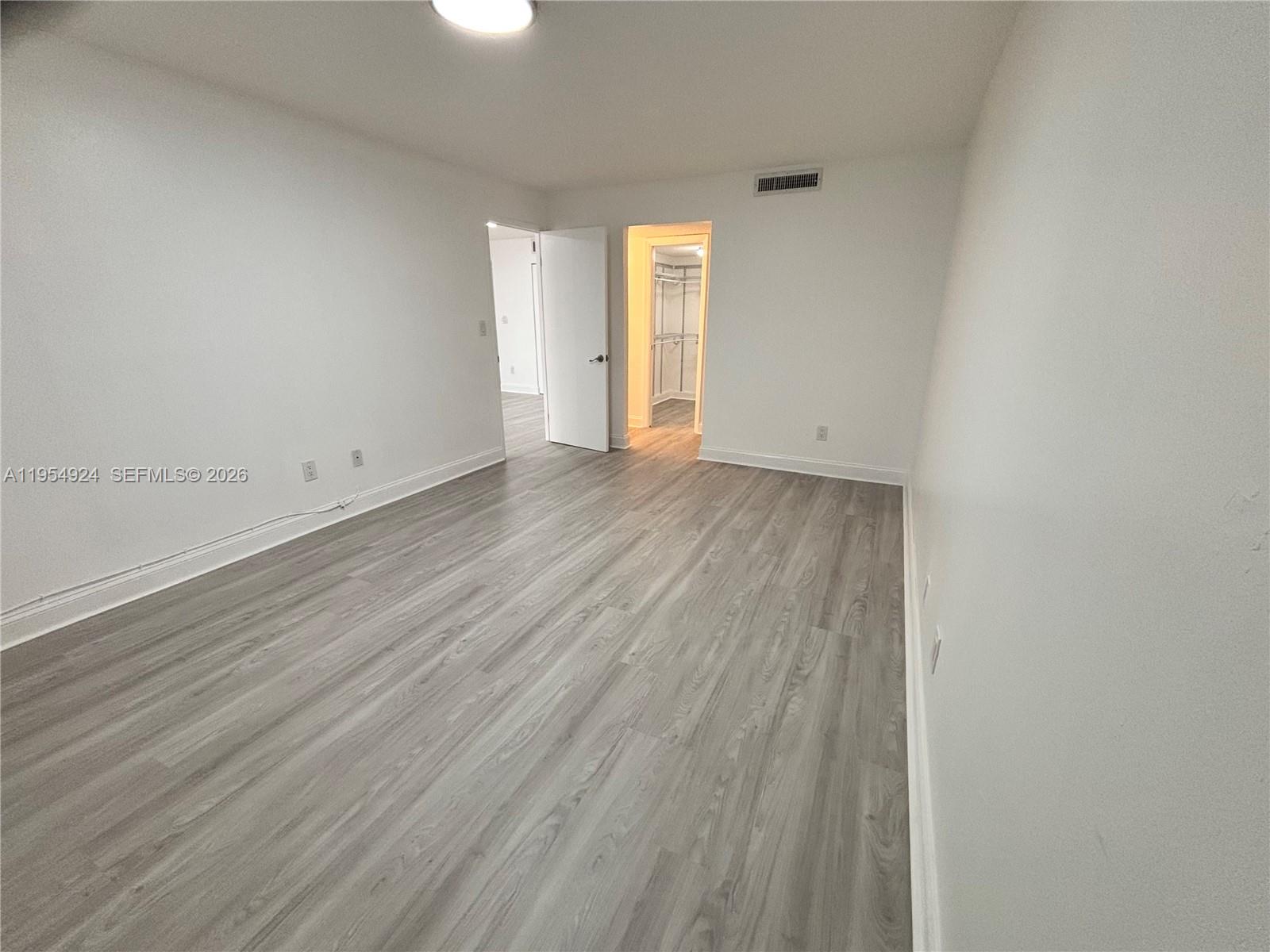 9301 Southwest 92nd Avenue, Unit A320 Miami, FL 33176 - Photo 3 of 20 a view of an empty room with wooden floor and a window