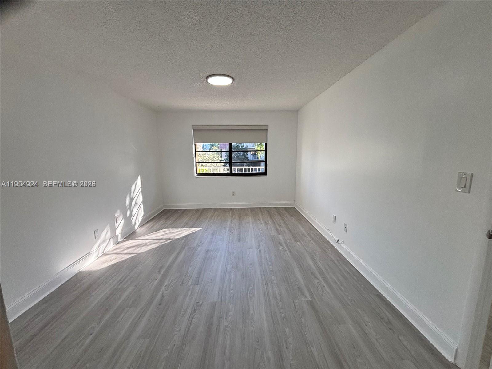 9301 Southwest 92nd Avenue, Unit A320 Miami, FL 33176 - Photo 4 of 20 wooden floor in an empty room with a window