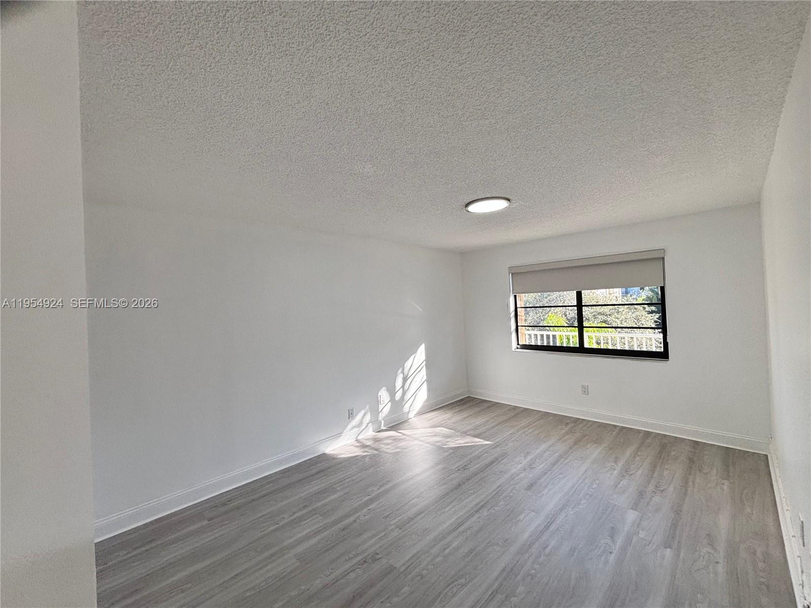 9301 Southwest 92nd Avenue, Unit A320 Miami, FL 33176 - Photo 5 of 20 a view of room with window and wooden floor