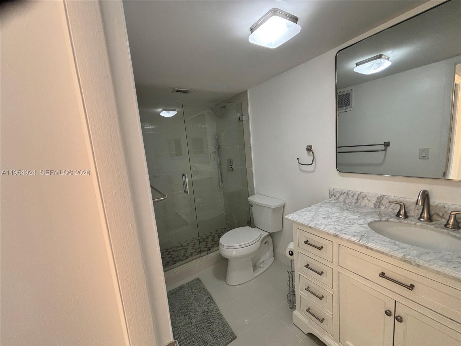 9301 Southwest 92nd Avenue, Unit A320 Miami, FL 33176 - Photo 6 of 20 a bathroom with a granite countertop sink toilet and shower