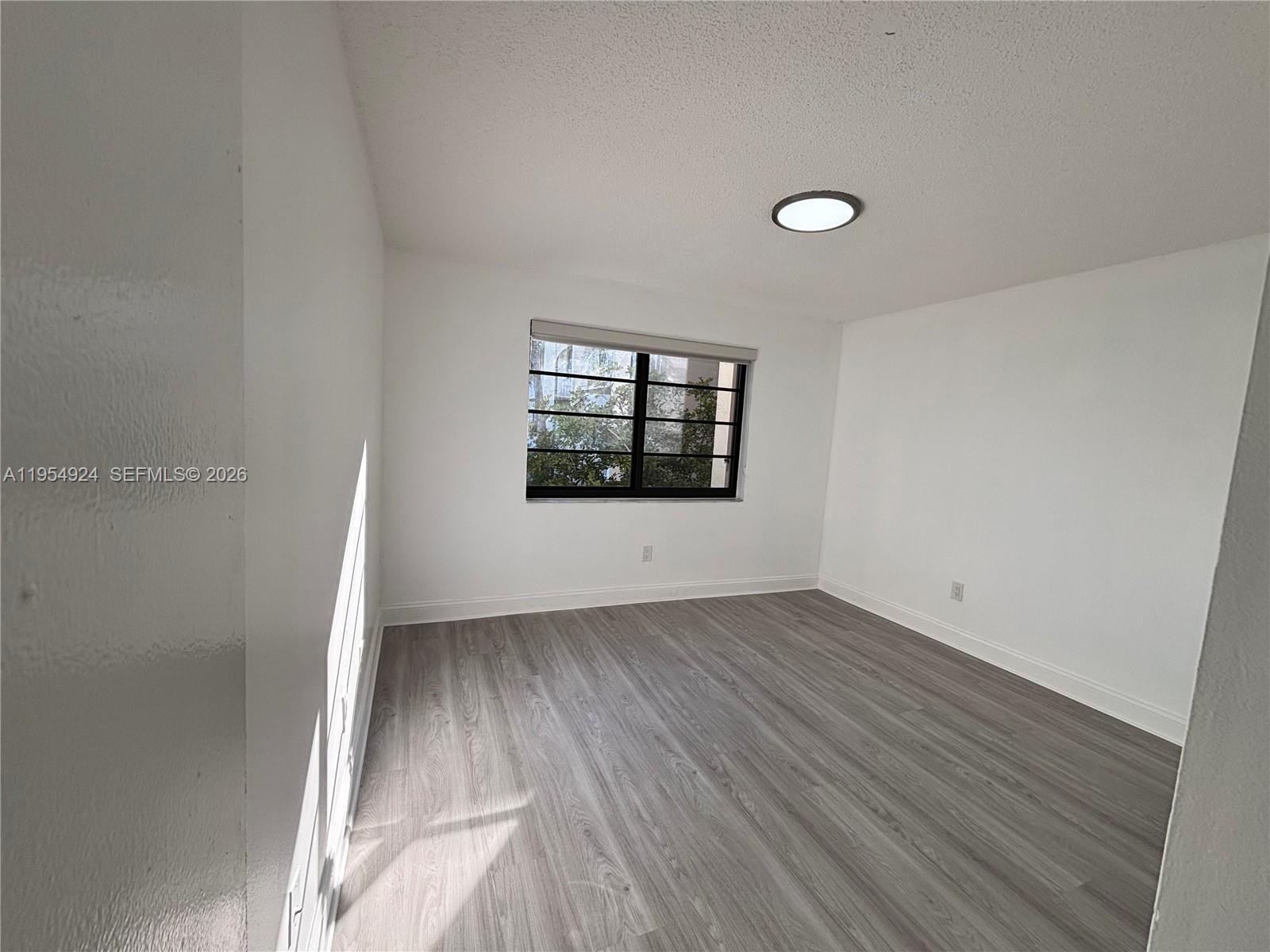 9301 Southwest 92nd Avenue, Unit A320 Miami, FL 33176 - Photo 9 of 20 an empty room with wooden floor and windows