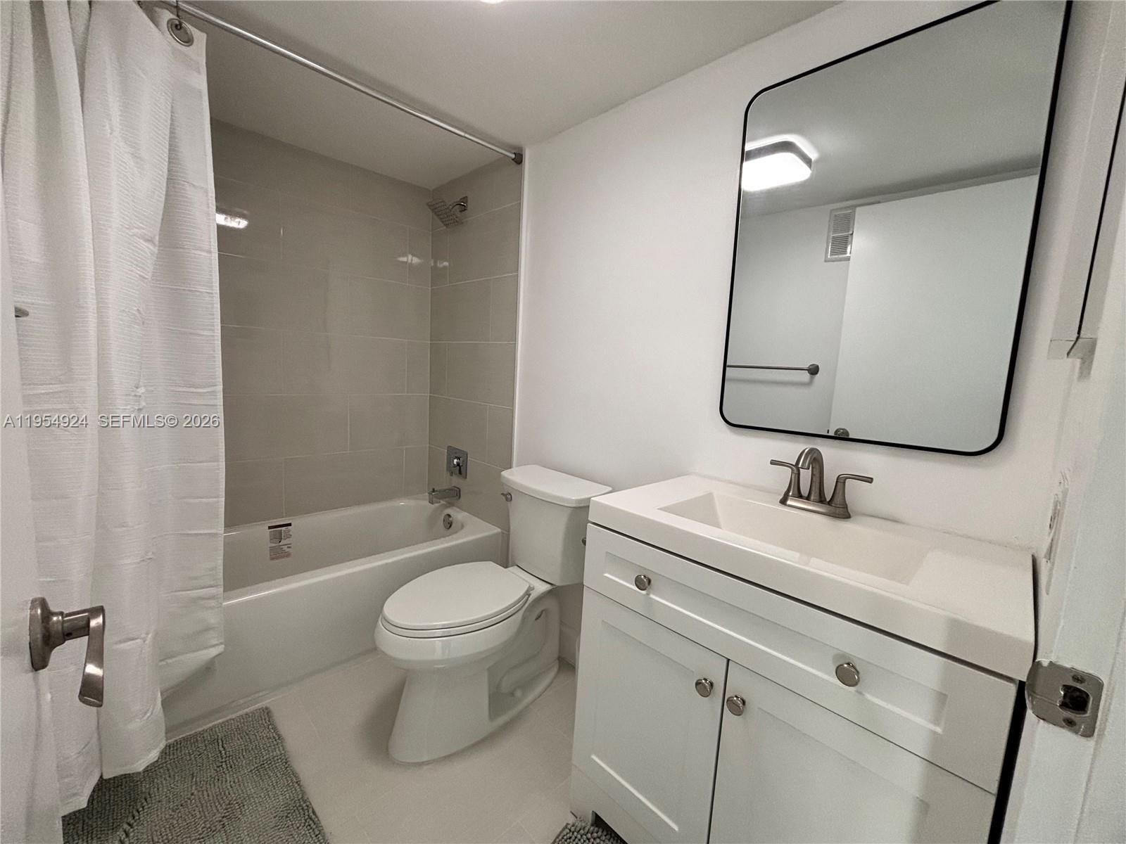 9301 Southwest 92nd Avenue, Unit A320 Miami, FL 33176 - Photo 10 of 20 a bathroom with a granite countertop toilet a sink and a mirror