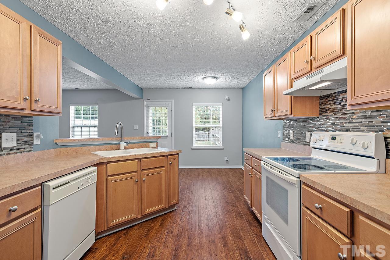 1909 Rathie Drive Durham, NC 27703 - Photo 14 of 32 a kitchen that has a sink a stove and wooden floor
