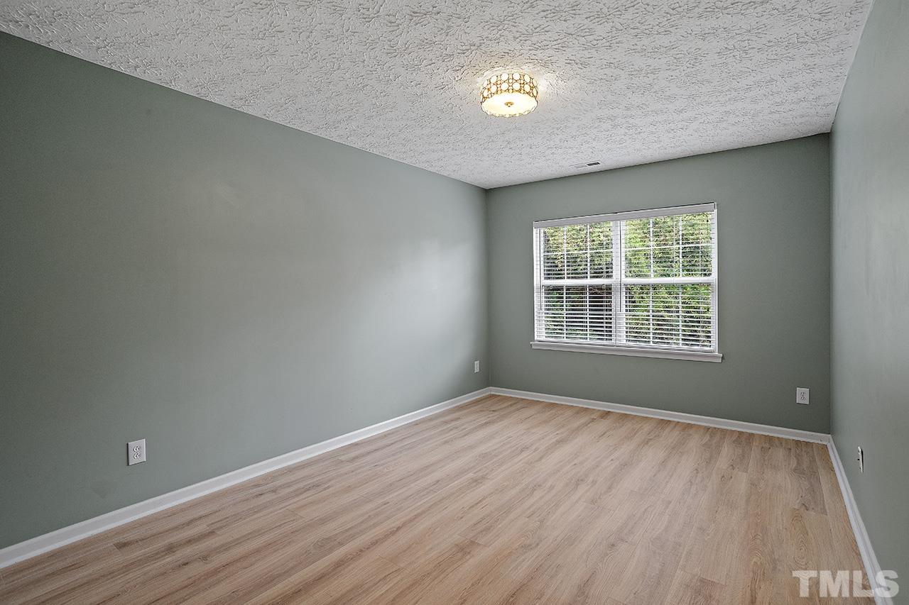 1909 Rathie Drive Durham, NC 27703 - Photo 16 of 32 wooden floor in an empty room with a window