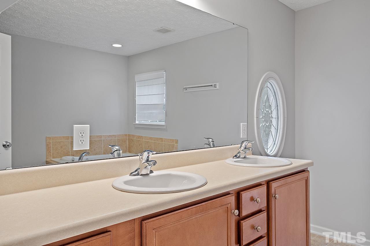 1909 Rathie Drive Durham, NC 27703 - Photo 23 of 32 a bathroom with a sink and a mirror