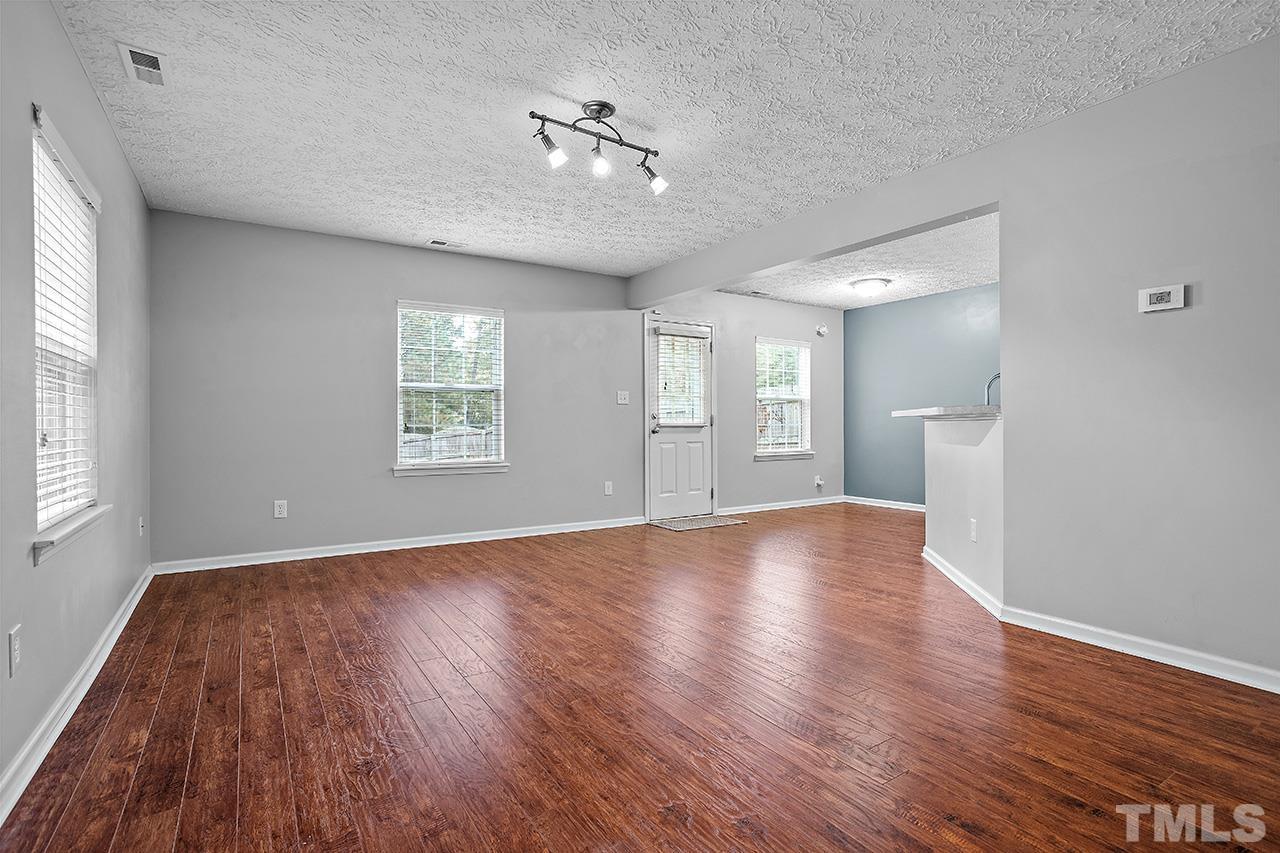 1909 Rathie Drive Durham, NC 27703 - Photo 3 of 32 a view of an empty room with a window and wooden floor