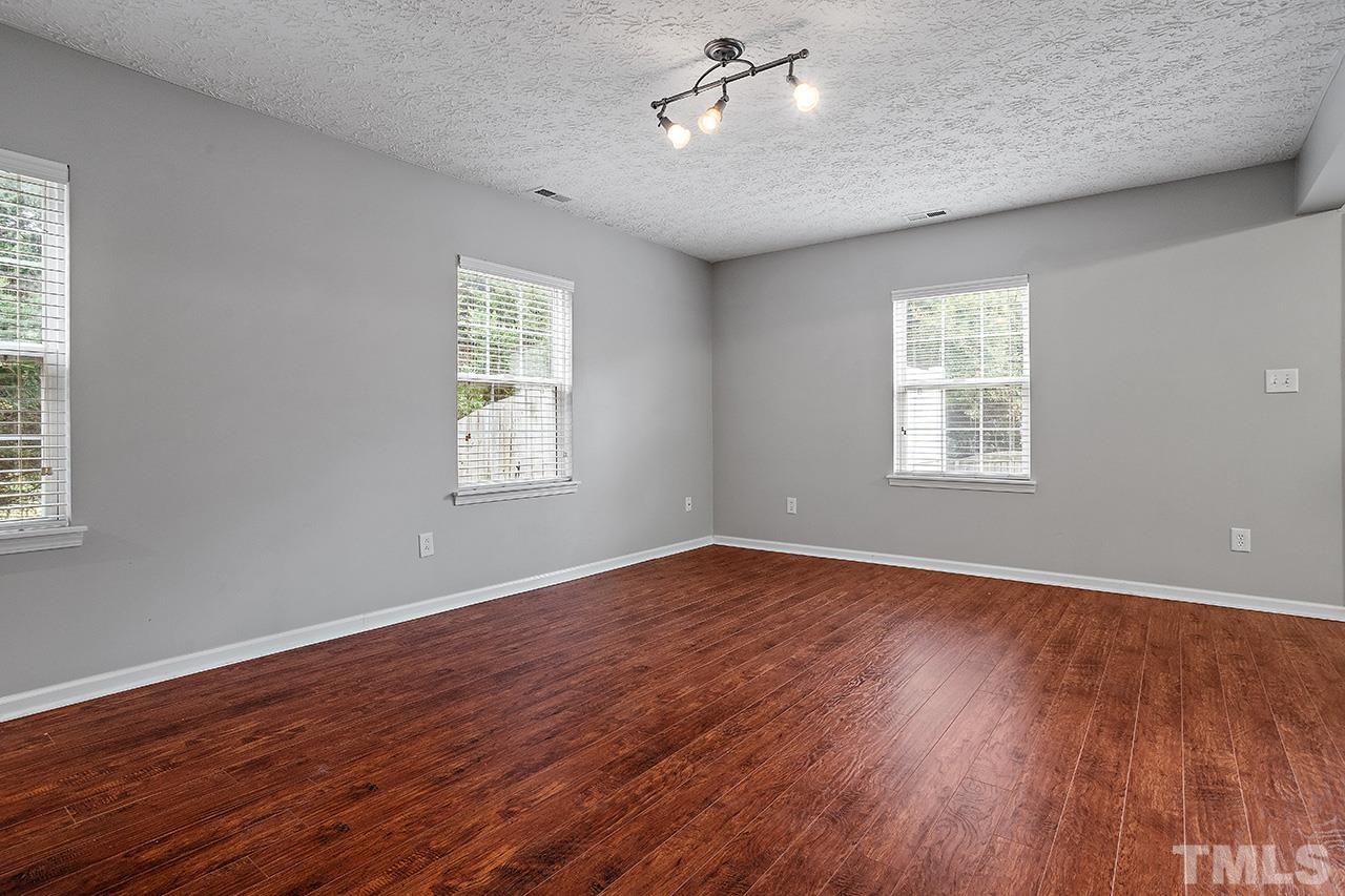 1909 Rathie Drive Durham, NC 27703 - Photo 4 of 32 a view of an empty room with wooden floor and a window