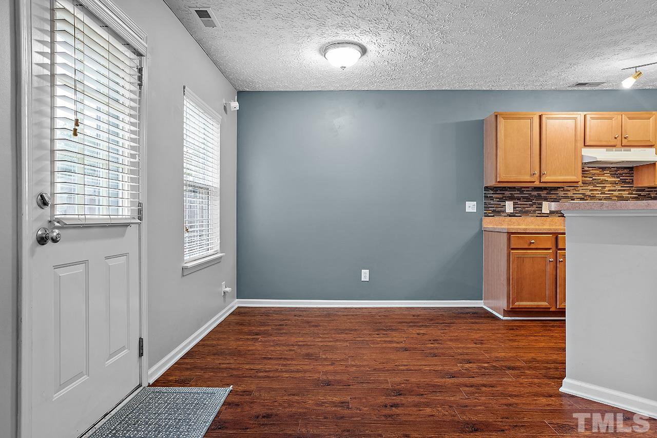 1909 Rathie Drive Durham, NC 27703 - Photo 7 of 32 a view of a kitchen with kitchen island a sink wooden floor and a large window