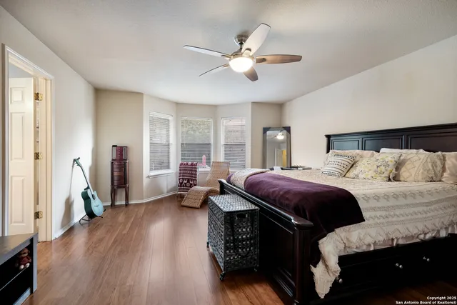a spacious bedroom with a bed and wooden floor