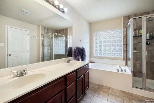 a bathroom with a bathtub double sink and mirror