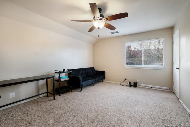 a living room with furniture and a ceiling fan