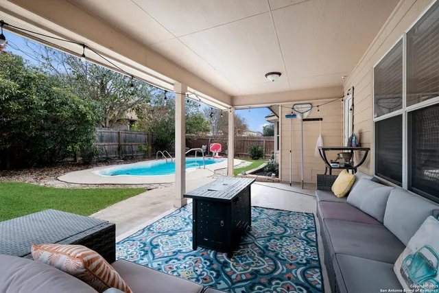 a living room with patio furniture and a garden
