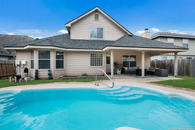 a view of a house with a patio and a yard