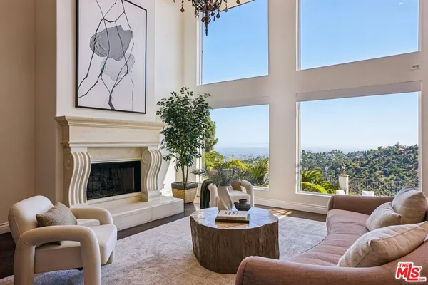 a living room with furniture potted plant and a large window
