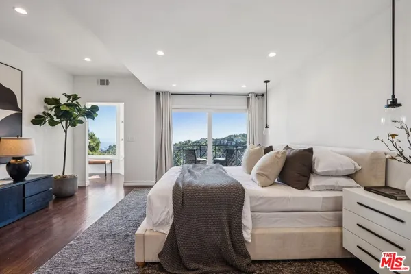 a view of a room with a large window and wooden floor