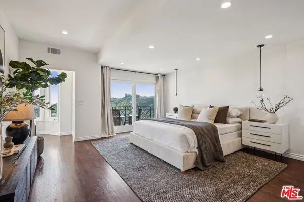 a view of a hallway with wooden floor and windows