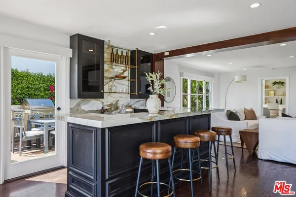 a kitchen with stainless steel appliances a dining table and chairs