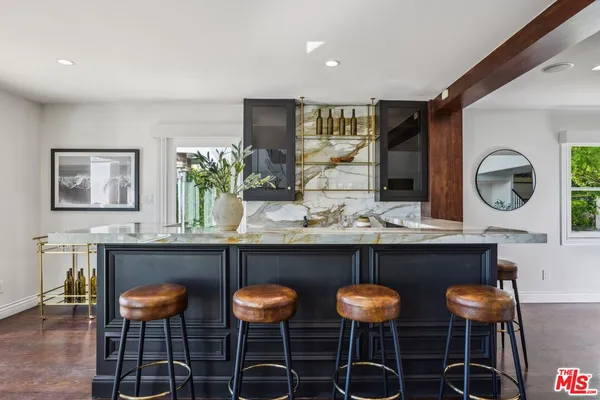 a living room with furniture a fireplace and potted plants