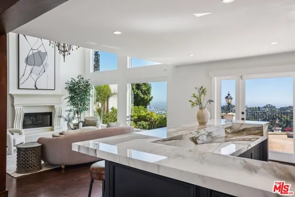 a living room with furniture a fireplace and a large window
