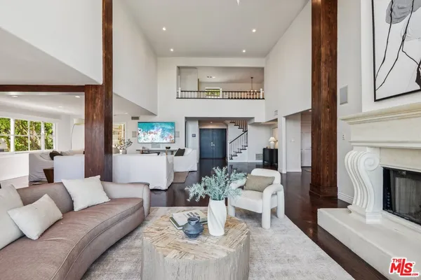 a living room with furniture kitchen view and a large window