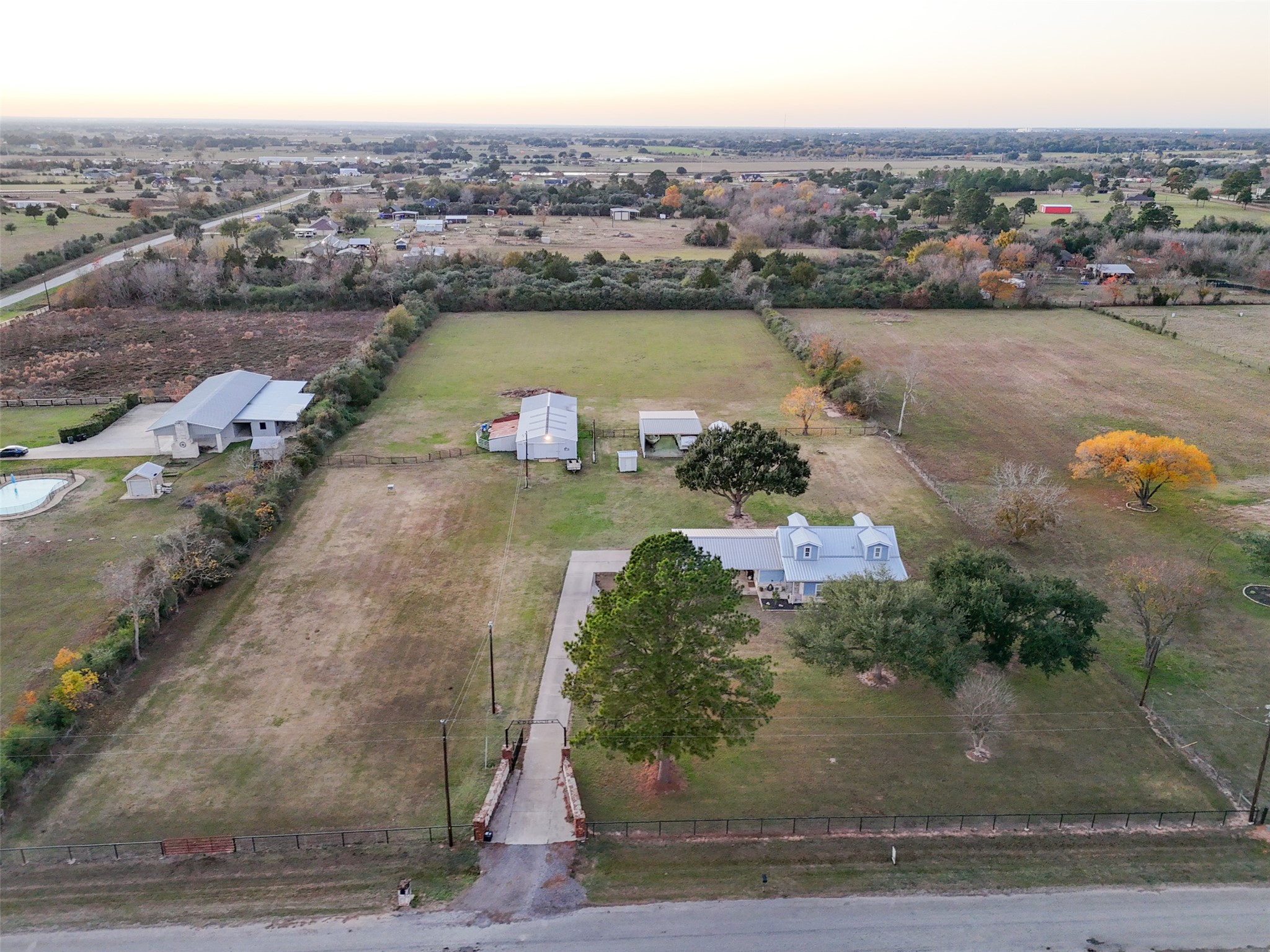 19989 Meadow Bend Road Hempstead, TX 77445 - Photo 28 of 35 Bird’s-eye view highlights the long concrete driveway, gated entry, home placement, and separation between living and agricultural areas.
