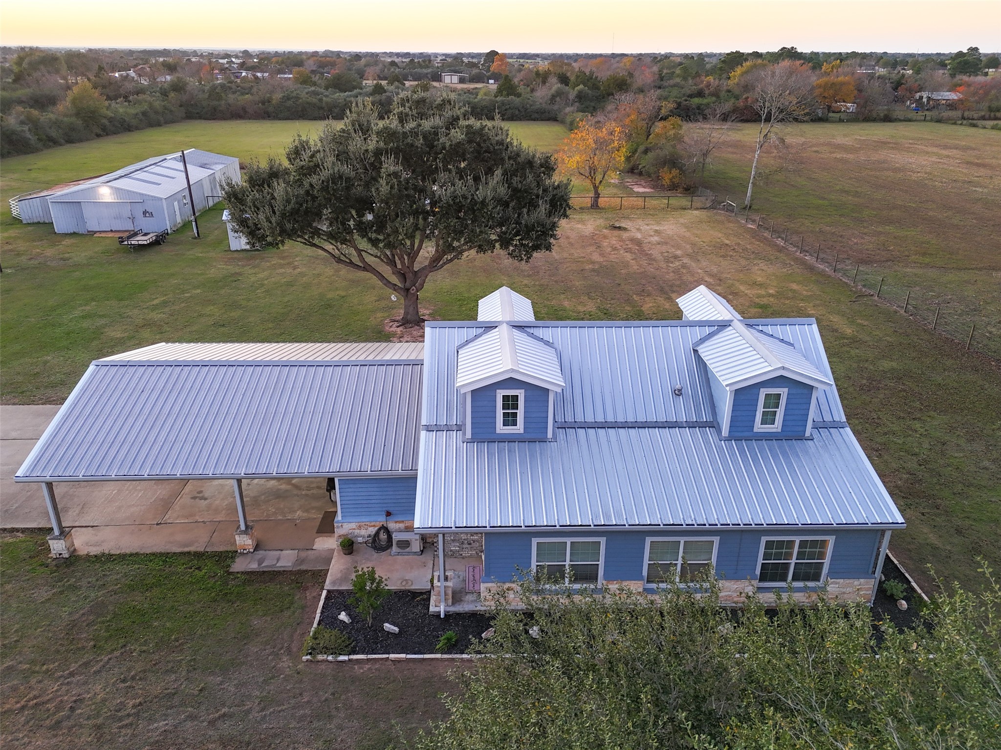19989 Meadow Bend Road Hempstead, TX 77445 - Photo 30 of 35 Aerial perspective shows the main residence, barn, and fenced pasture areas with mature trees providing natural privacy.