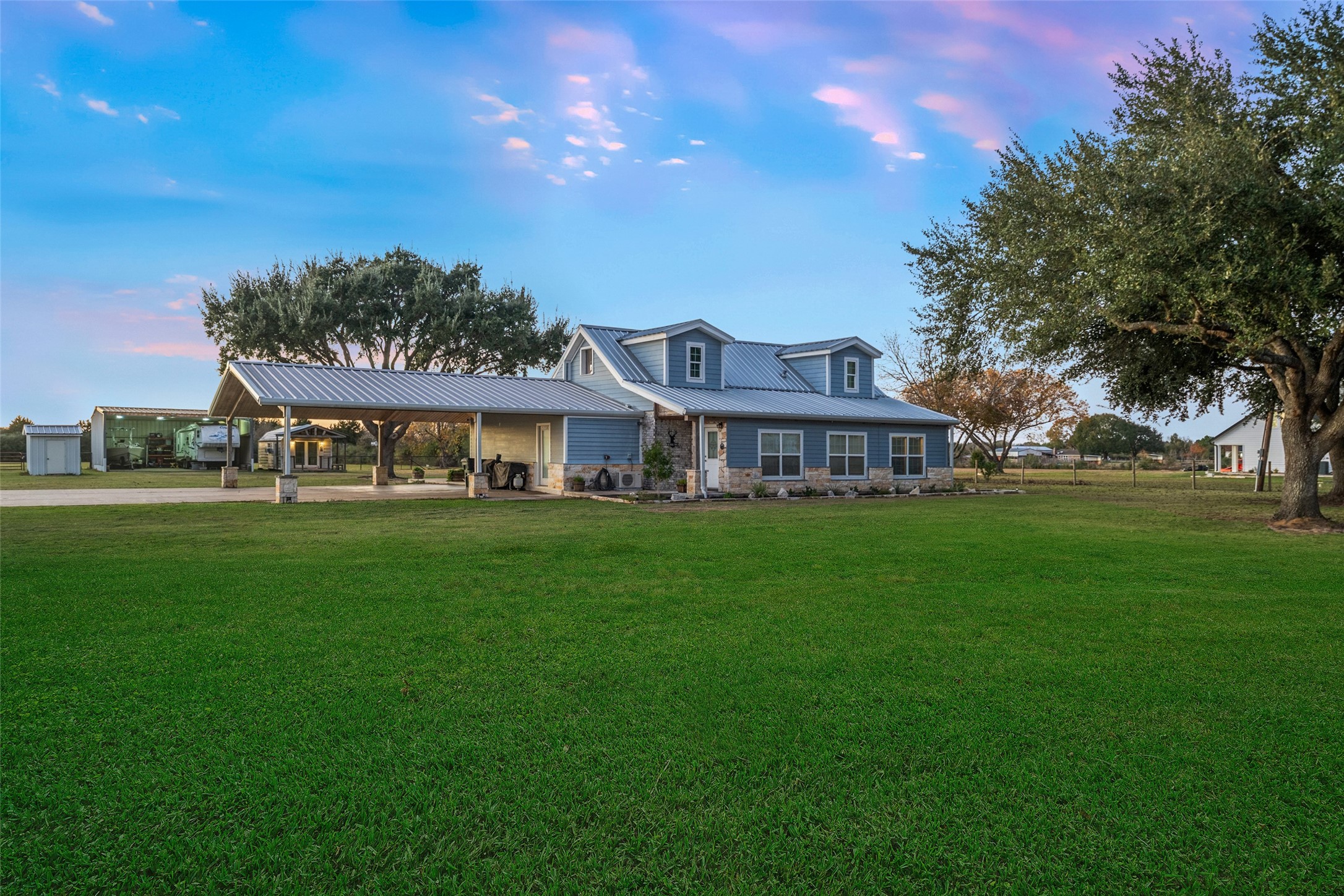19989 Meadow Bend Road Hempstead, TX 77445 - Photo 35 of 35 Wide front lawn highlights the home’s attractive curb appeal, metal roof (approx. 2019), and spacious covered parking area with stone-accented columns.