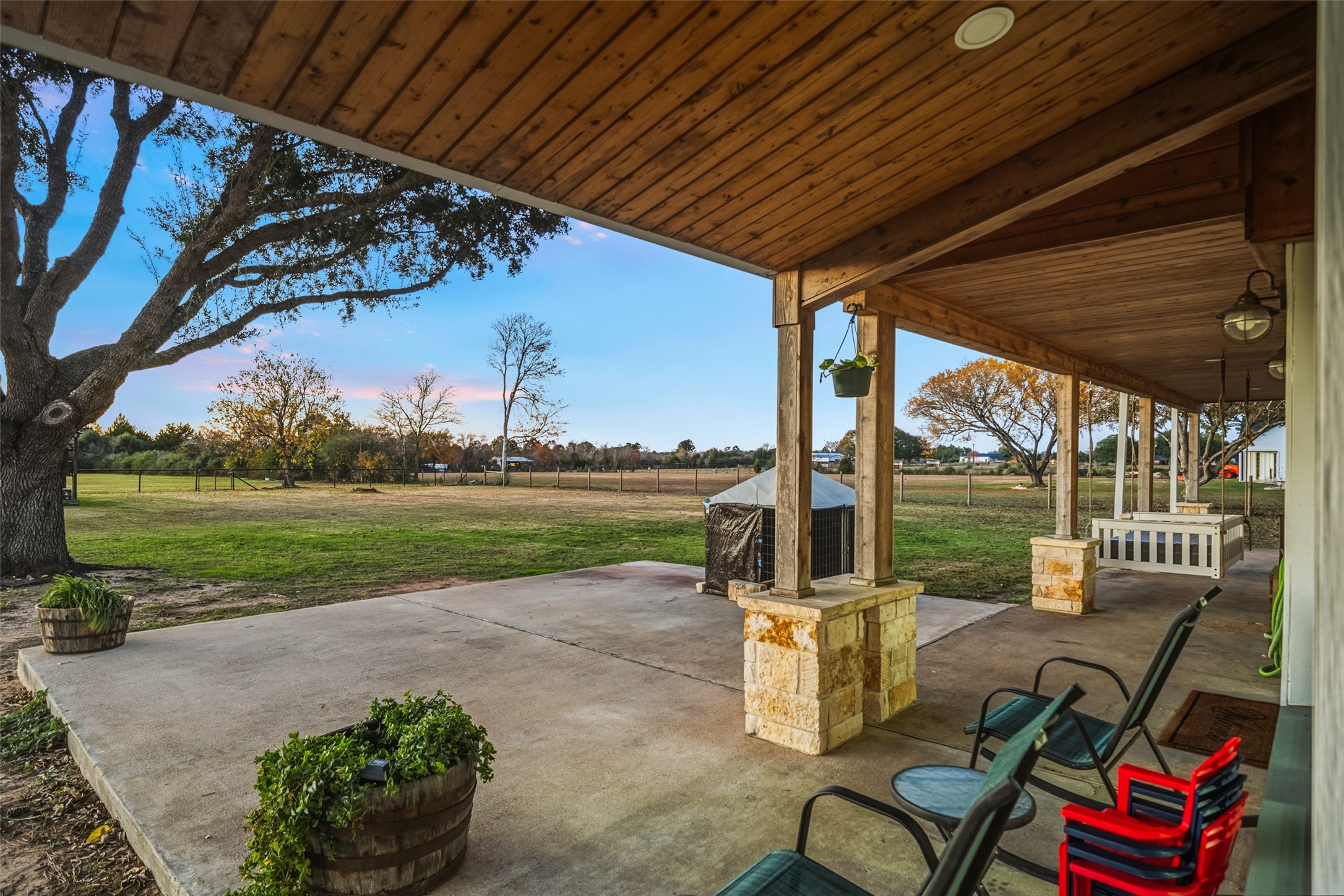 19989 Meadow Bend Road Hempstead, TX 77445 - Photo 5 of 35 Covered porch with wood ceiling offers a comfortable outdoor seating area overlooking the fenced pasture and open green space.
