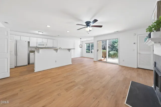a view of an empty room with window and fireplace