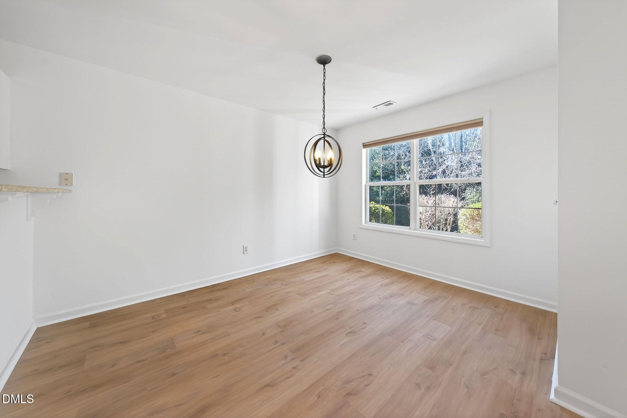 3612 Wellington Ridge Loop Cary, NC 27518 - Photo 15 of 35 a view of an empty room with window and wooden floor