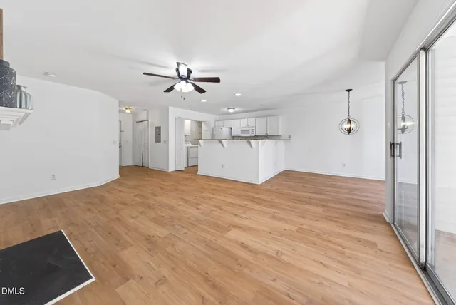 an empty room with a window and a ceiling fan