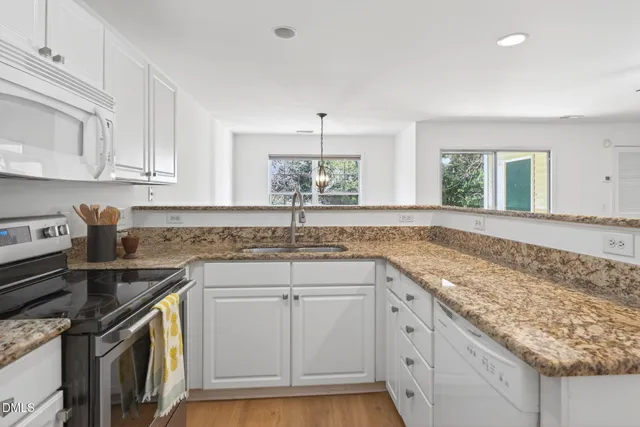 a kitchen that has a sink a stove and cabinets