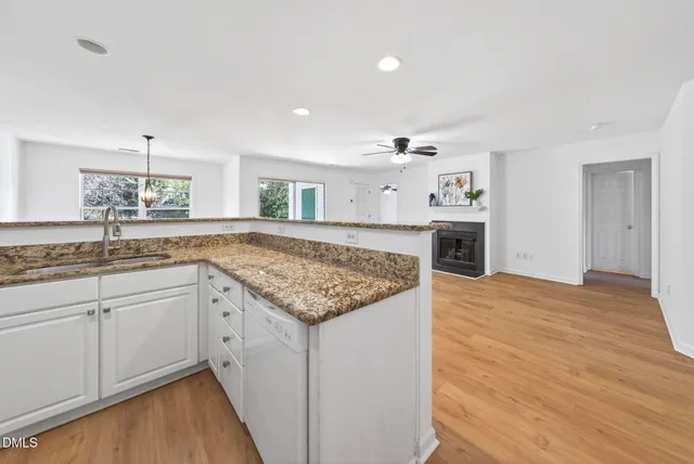 a hall with kitchen island a sink dishwasher stove and wooden cabinets