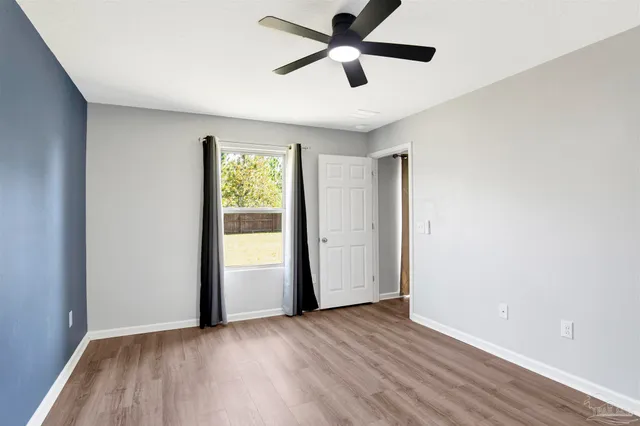 a view of empty room with wooden floor