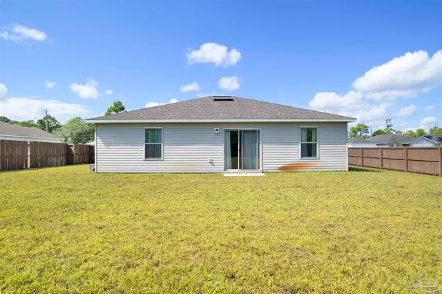 a view of a house with a backyard