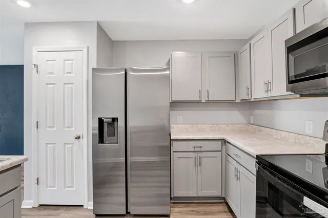 a kitchen with white cabinets and stainless steel appliances