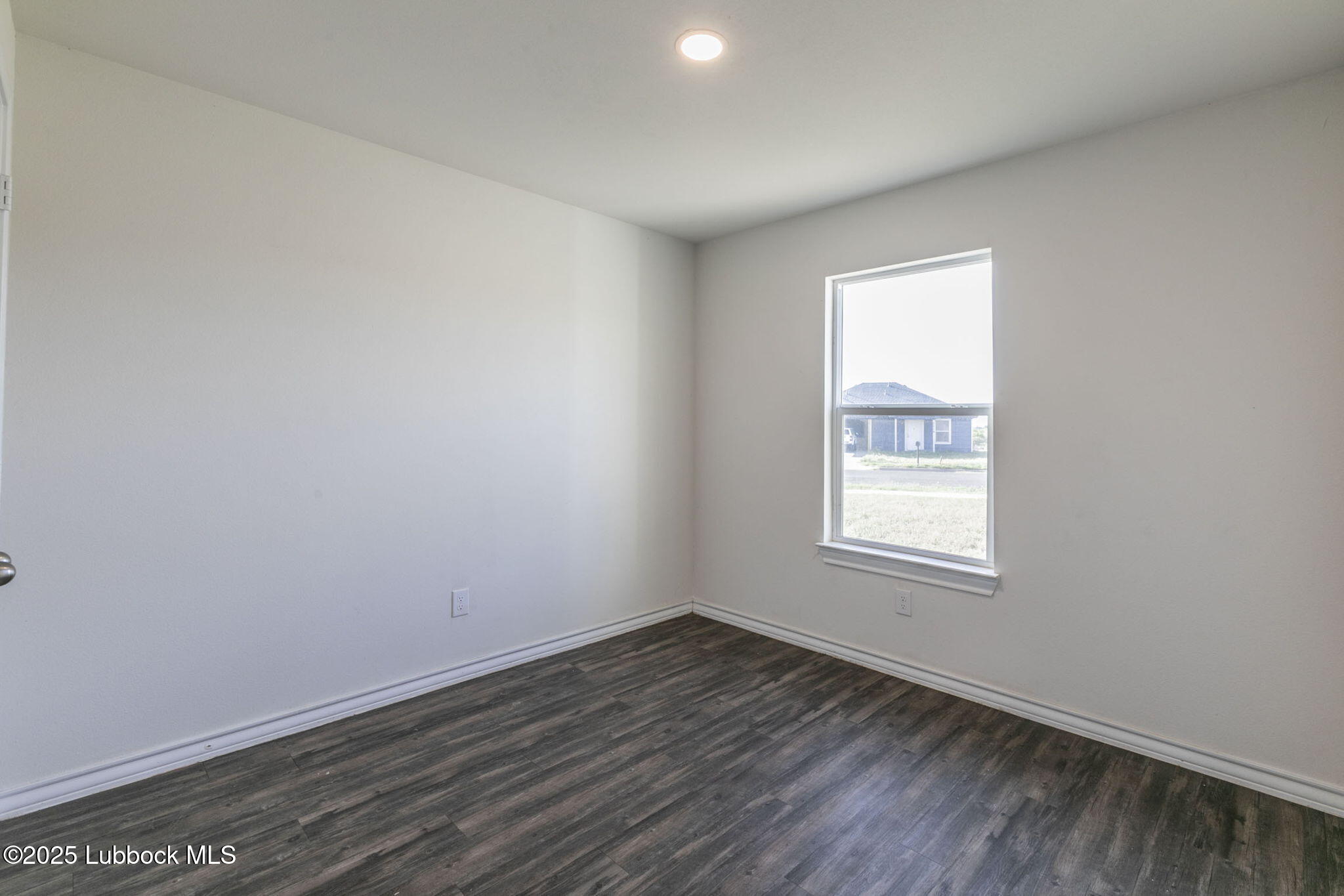 3511 East Colgate Street Lubbock, TX 79403 - Photo 13 of 18 an empty room with wooden floor and windows