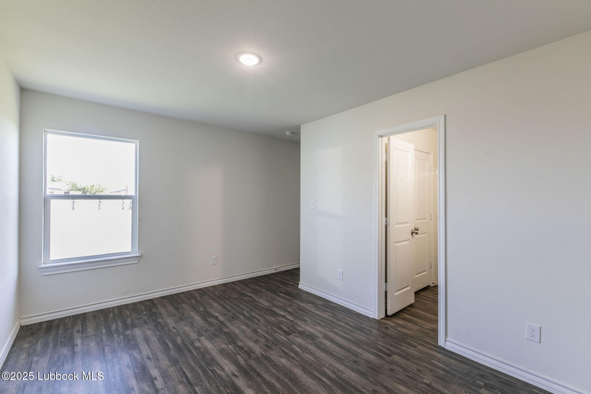 3511 East Colgate Street Lubbock, TX 79403 - Photo 8 of 18 an empty room with wooden floor and windows