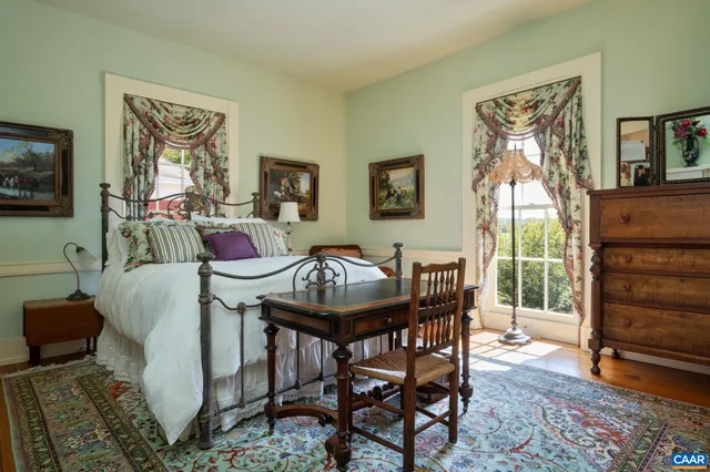 a living room with furniture a rug a lamp and a large window
