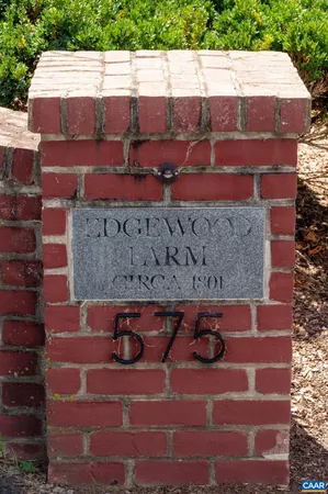 a view of a house with a big yard and large trees