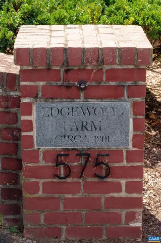 a view of a house with a big yard and large trees