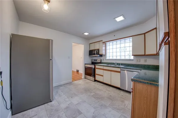 a large kitchen with stainless steel appliances granite countertop a refrigerator and a sink