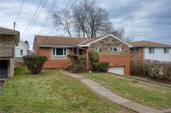 a front view of a house with yard and green space